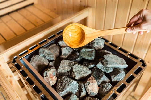 A sauna generates intense heat from a traditional rock-laden stove.