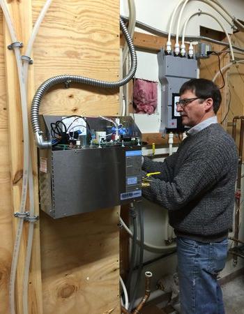  Ric Carpenter with Wolff Bros. Supply Inc. adjusts the wiring on a Mr.Steam generator. 